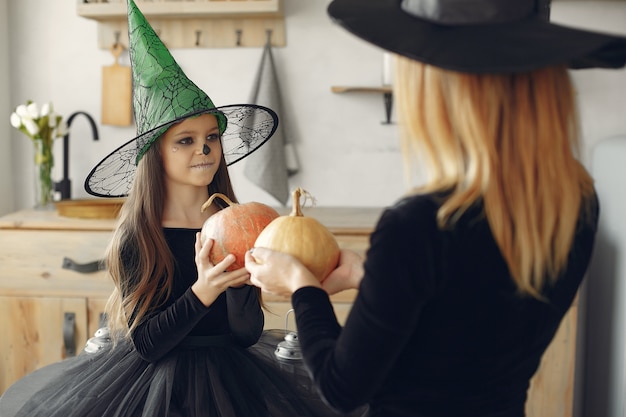 Víspera de Todos los Santos. Madre e hija disfrazadas de halloween. Familia en casa.