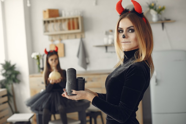 Víspera de Todos los Santos. Madre e hija disfrazadas de halloween. Familia en casa.