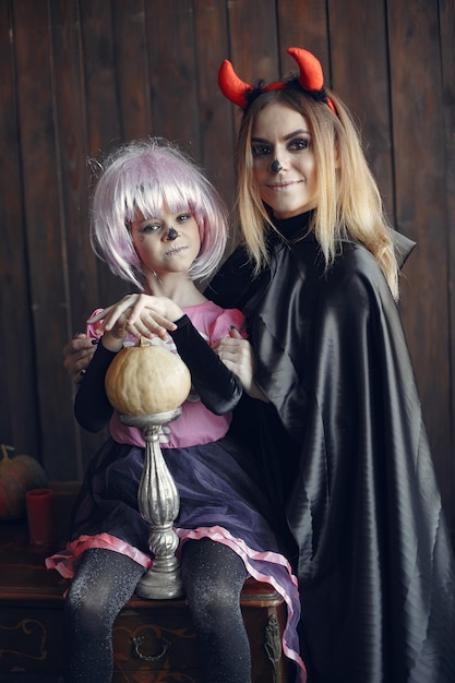 Víspera de Todos los Santos. Madre e hija disfrazadas de halloween. Familia en casa.