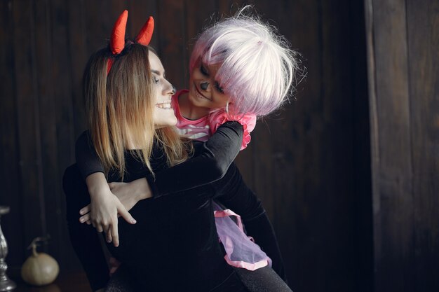 Víspera de Todos los Santos. Madre e hija disfrazadas de halloween. Familia en casa.