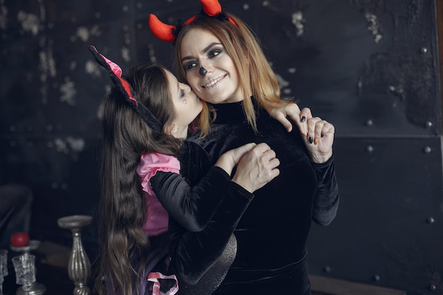 Víspera de Todos los Santos. Madre e hija disfrazadas de halloween. Familia en casa.