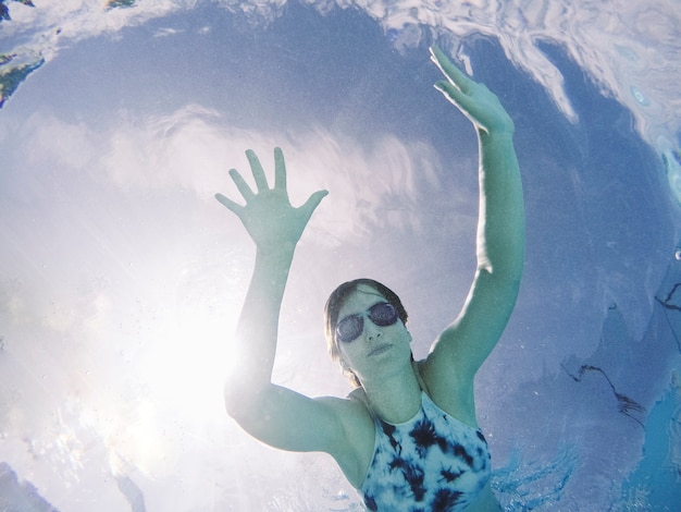 Vista de abajo de mujer buceando en piscina