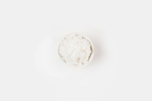 Una vista aérea de arroz cocido cocido en un tazón sobre fondo blanco