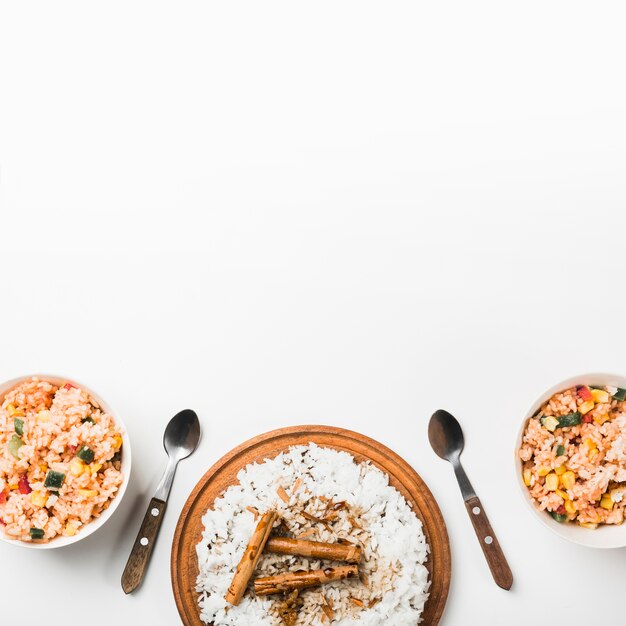 Vista aérea de arroz frito y de vapor chino con palitos de canela en superficie blanca