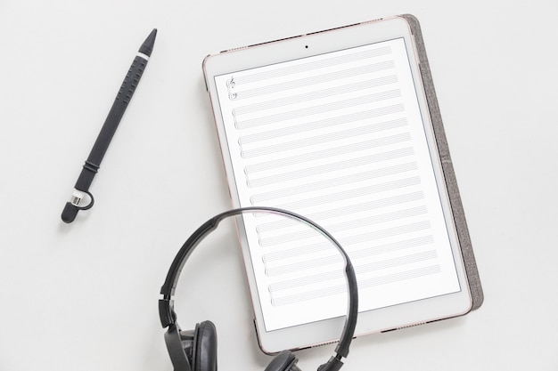 Vista aérea de auriculares en tableta digital gráfica y lápiz óptico un fondo blanco