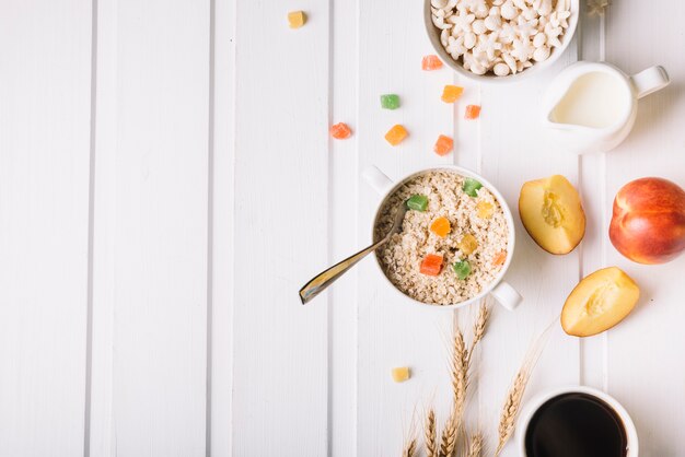 Vista aérea de avena con leche y manzana sobre la mesa blanca