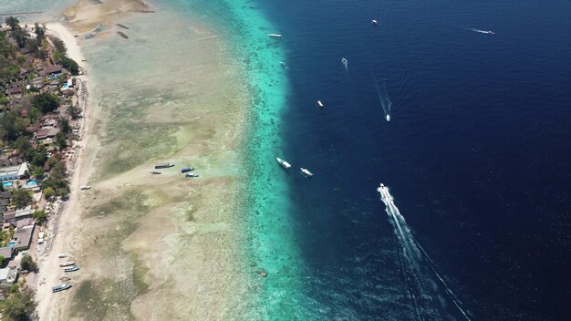 Vista aérea de los barcos que navegan en el océano azul de la costa