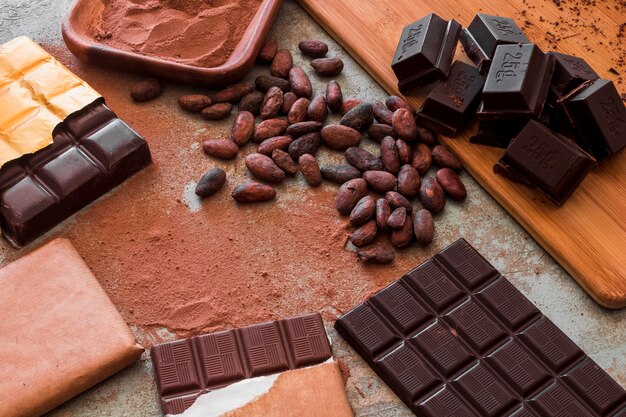 Vista aérea de barras de chocolate con cacao en polvo y frijoles crudos