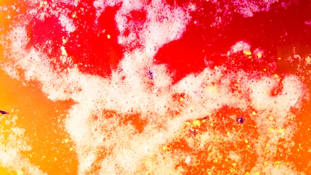 Una vista aérea de una bomba de baño amarilla roja espuma en agua