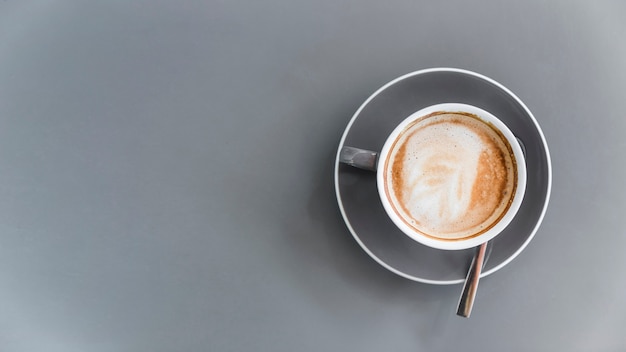 Vista aérea de café con leche sobre fondo gris