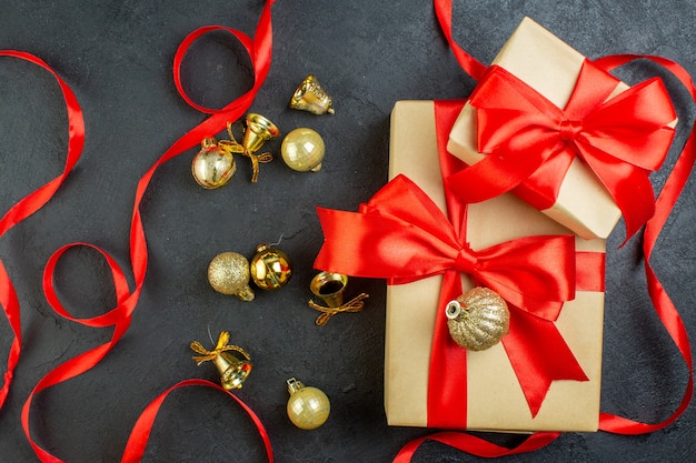 Vista aérea de la caja de regalo con cinta roja y accesorios de decoración sobre fondo oscuro