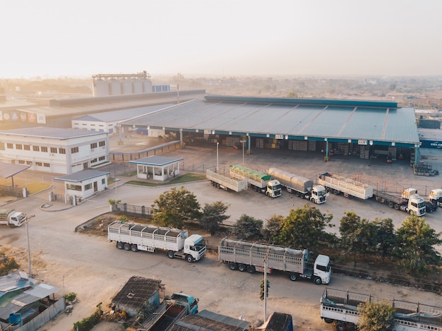 Vista aérea de camiones de fábrica estacionados cerca del almacén durante el día