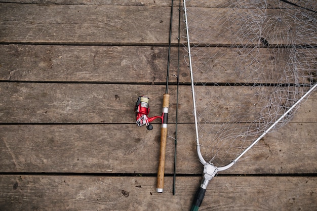 Vista aérea de la caña de pescar y la red en el muelle de madera