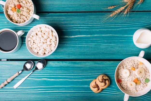 Vista aérea de cereales, avena con café y té en la mesa de color turquesa