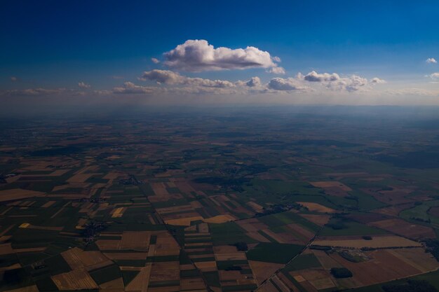 Vista aérea del cielo azul con nubes blancas flotando sobre los campos