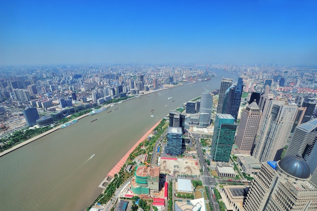Foto gratuita vista aérea de la ciudad de shanghai con arquitectura urbana sobre el río y el cielo azul en el día.