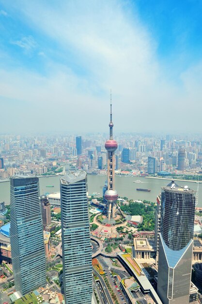 Vista aérea de la ciudad de Shanghái en el día con cielo azul y nubes con la Torre de la Perla Oriental