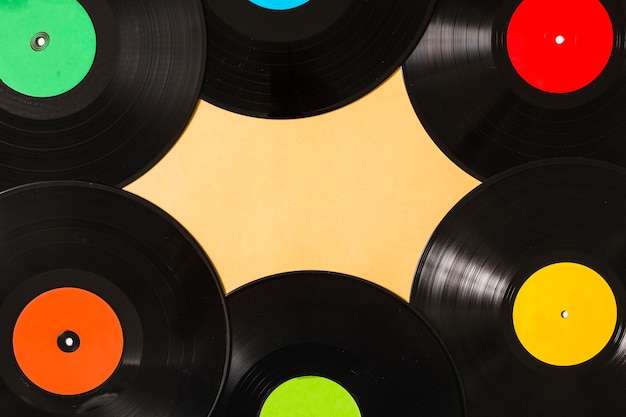 Foto gratuita vista aérea del colorido disco de vinilo negro sobre fondo beige