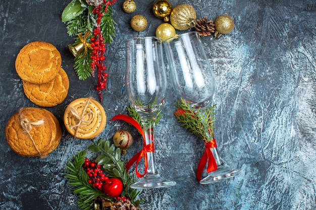 Vista aérea de copas de vidrio, accesorios de decoración, galletas apiladas en la mesa oscura