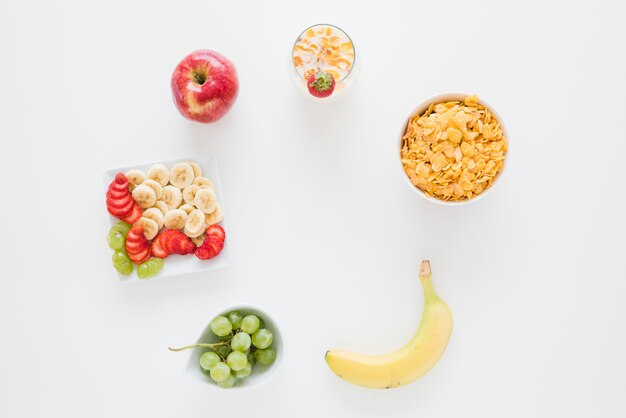 Una vista aérea de copos de maíz con manzana; plátano; Fresas y uvas aisladas sobre fondo blanco