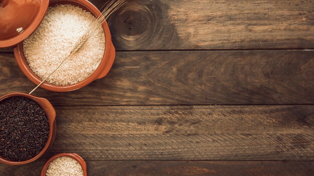 Vista aérea de cuencos de grano de arroz saludable en la mesa de madera