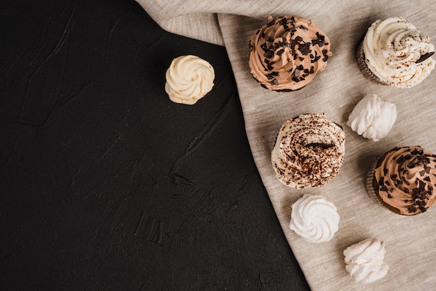 Foto gratuita vista aérea de cupcakes y cremas batidas en tela