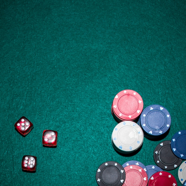 Foto gratuita vista aérea de dados rojos y fichas de casino se apilan en la mesa de póquer verde