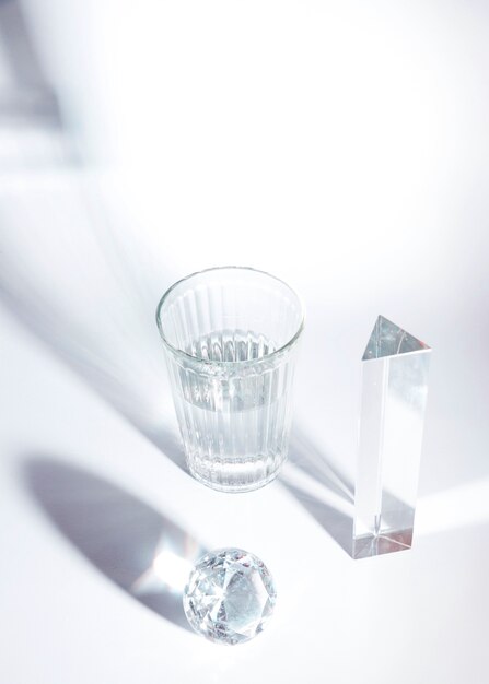Una vista aérea de diamante brillante; Prisma y vidrio con sombra sobre fondo blanco