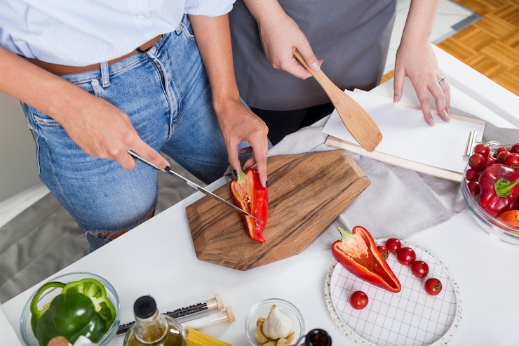 Foto gratuito una vista aérea de dos mujeres preparando la comida juntas.
