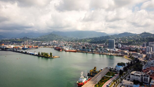 Vista aérea de drone de la costa en Batumi, Georgia, el puerto del mar Negro, barcos, edificios, montañas