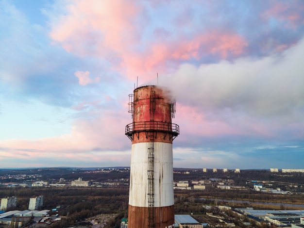 Vista aérea de drone de la estación termal al atardecer con humo saliendo del tubo.