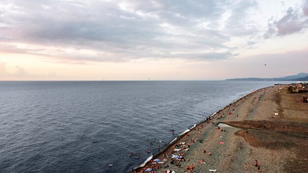 Vista aérea de drone de una playa en Batumi Georgia al atardecer mar Negro nadando y descansando gente