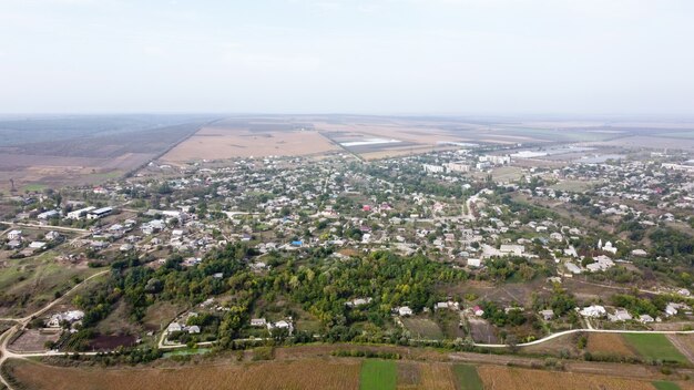 Vista aérea de drone del pueblo de Moldavia, varios edificios y árboles, niebla en el aire