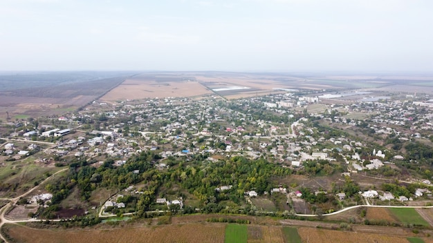 Vista aérea de drone del pueblo de Moldavia, varios edificios y árboles, niebla en el aire