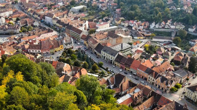 Vista aérea de drones del centro histórico de Sighisoara Rumania Calles de edificios antiguos con coches