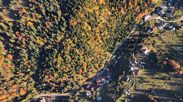 Vista aérea de drones de la naturaleza en Rumania Pueblo de las montañas de los Cárpatos en un valle cubierto de colinas