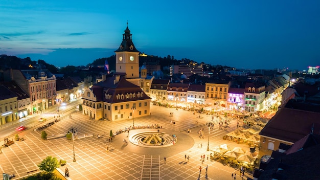 Vista aérea de drones de la Plaza del Consejo en Brasov por la noche Rumania