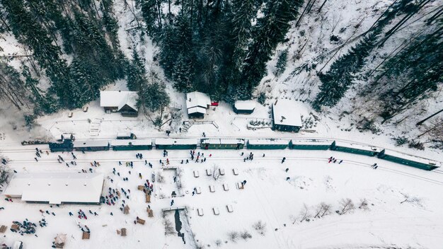 Vista aérea de drones del tren de vapor Mocanita en una estación de tren en la nieve del invierno