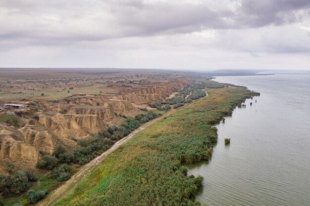 Vista aérea en el enorme lago con hermosas dunas de arena y orilla verde y cielo de la tarde