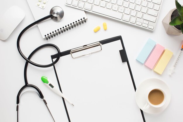 Vista aérea del escritorio médico con taza de café y notas adhesivas sobre la mesa