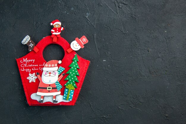 Vista aérea del estado de ánimo navideño con accesorios de decoración y caja de regalo de año nuevo en una superficie oscura