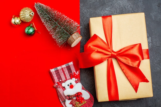 Foto gratuita vista aérea del estado de ánimo navideño con calcetín de regalo de accesorios de decoración de árbol de navidad sobre fondo rojo y negro