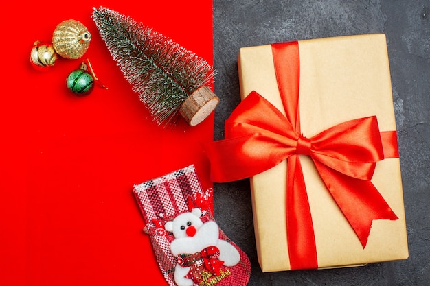 Vista aérea del estado de ánimo navideño con calcetín de regalo de accesorios de decoración de árbol de navidad sobre fondo rojo y negro