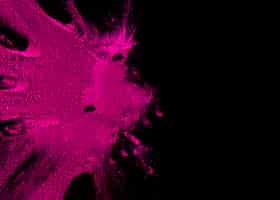 Foto gratuita vista aérea de la explosión de polvo de color rosado con espacio de copia para texto en superficie negra