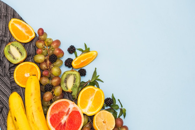 Una vista aérea de frutas tropicales frescas sobre fondo azul