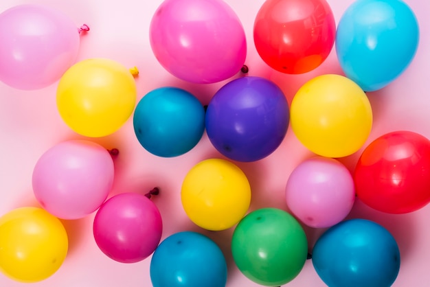 Una vista aérea de globos inflados de colores sobre fondo rosa