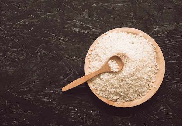 Vista aérea de granos de arroz tazón de madera con cuchara