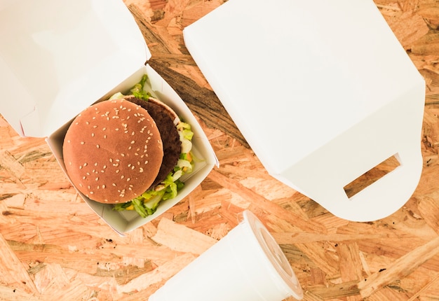 Foto gratuita una vista aérea de hamburguesa en paquete sobre el fondo de madera