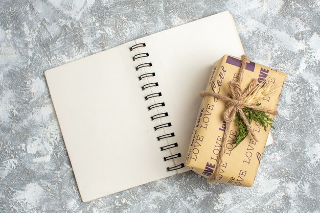 Vista aérea del hermoso regalo lleno de Navidad con inscripción de amor en el cuaderno abierto en la mesa de hielo