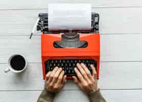 Foto gratuita vista aérea de un hombre escribiendo en una máquina de escribir retro